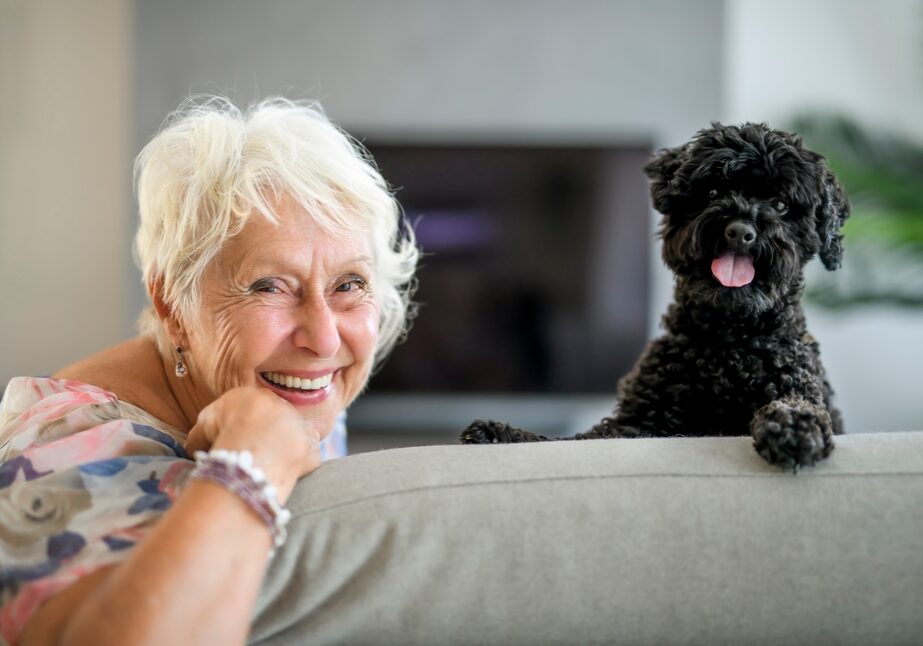 A,Cute,Senior,Woman,With,Poodle,On,The,Living,Room